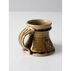 a brown and black mug sitting on top of a table