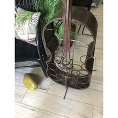 a metal sculpture sitting on top of a hard wood floor next to a green plant