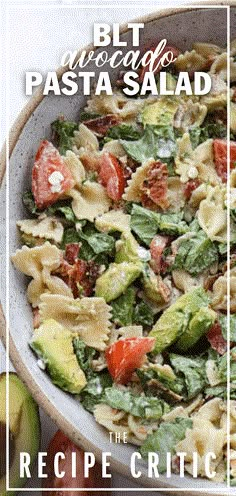 a bowl full of pasta salad with tomatoes and avocado