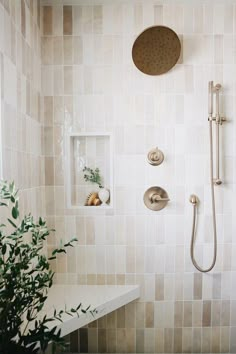 a bathroom with a shower head, hand held shower faucet and tiled walls