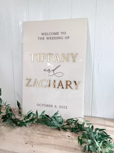 a welcome sign with greenery on the floor