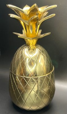 a gold pineapple shaped vase sitting on top of a table