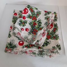 two pieces of cloth with holly and cherries on them sitting on a white surface