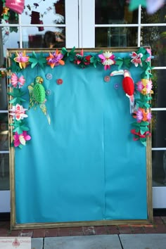 a blue wall with flowers and birds on it in front of a storefront window