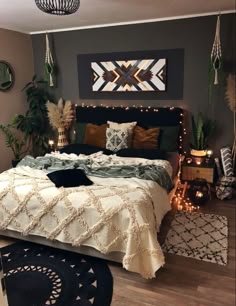 a bedroom decorated in black, white and gold with plants on the wall above the bed