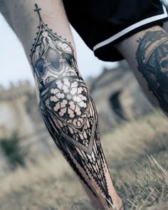 a man's leg with tattoos on it and an owl in the middle of his arm