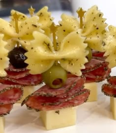 several appetizers are arranged on sticks with olives