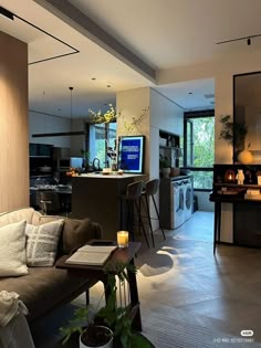 a living room filled with furniture next to a kitchen