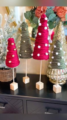 someone is making christmas trees out of yarn and wood skewers on the floor