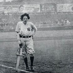 an old black and white photo of a baseball player holding a bat on the field