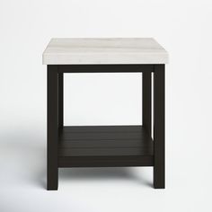 a black and white side table with a marble top on a plain surface, viewed from the front