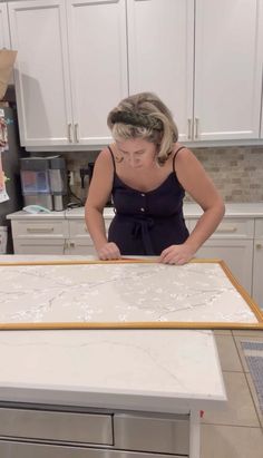 a woman standing in front of a white counter top