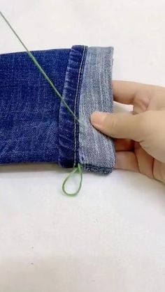 someone is cutting through the back pocket of a pair of blue jeans with a pair of scissors