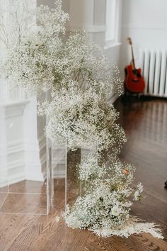 a vase filled with baby's breath flowers sitting on top of a wooden floor