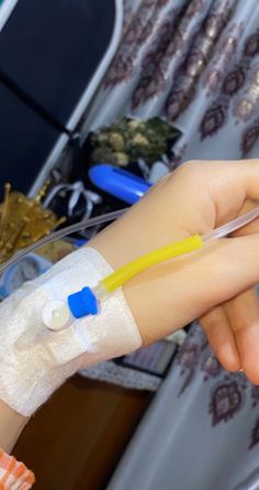 a hand with an iv attached to it holding something in its palm and wearing a bandage around the arm