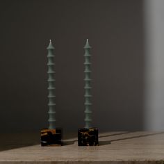 two tall candles sitting on top of a table