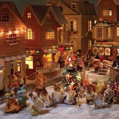 a christmas scene with teddy bears and other holiday decorations in front of a lit - up village