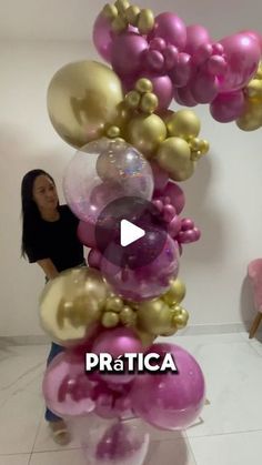 a woman standing next to a bunch of balloons