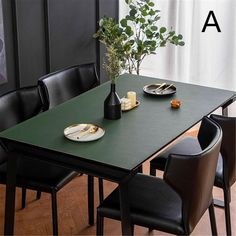 a green table with black chairs and plates on it