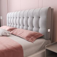 a bed with pink sheets and pillows in a bedroom