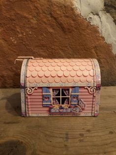 a small pink tin box with a window on it