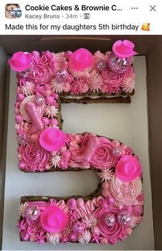 the letter e is made out of cookies and pink frosting flowers on top of it