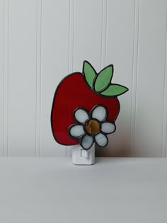 a red apple with a flower on it