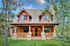 a log cabin home surrounded by trees and grass