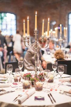 a dining table with candles and place settings