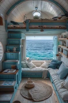 the inside of a tiny house with a window and couch in it, overlooking the ocean