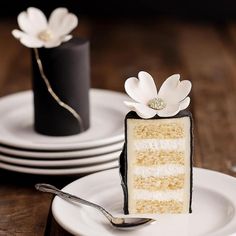 a piece of cake sitting on top of a white plate next to a black and white vase