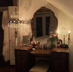 a bedroom with a vanity, mirror and chandelier in the middle of it