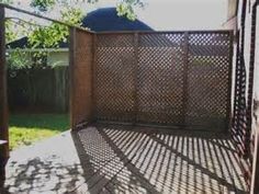 an iron gate in front of a house on a sunny day with shadows from the sun