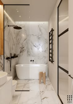 a bathroom with white marble walls and flooring, along with a freestanding bathtub