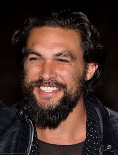 a close up of a person with a smile on his face and beard smiling at the camera