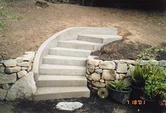 there is a stone staircase next to potted plants