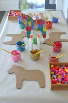 the table is set up with crafting supplies for kids to make their own unicorns