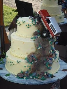 there is a wedding cake with a train on top and flowers all over the bottom