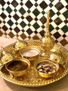 a golden plate with three bowls on it