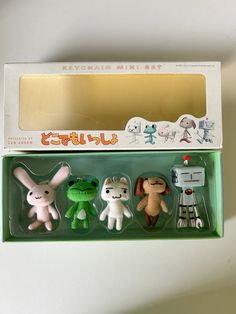 three small toy animals in a box on a table