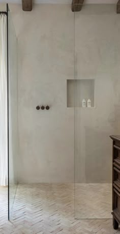 a bathroom with white walls and wooden floors