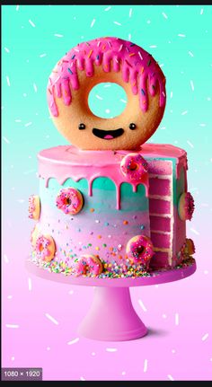 there is a pink cake with sprinkles and a donut on top