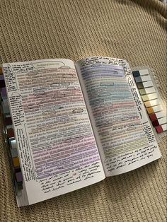 an open book sitting on top of a couch covered in lots of writing and colored pencils