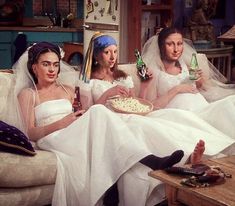 three women dressed in wedding attire sitting on a couch with pizza and beer bottles,