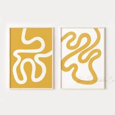 two yellow and white art prints on the wall, one with an image of a snake