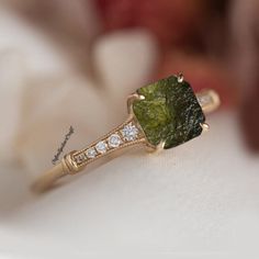 a close up of a ring with a green stone