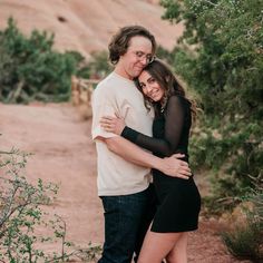 a man and woman hugging each other in the desert