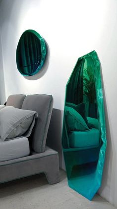 a room with a couch, chair and round mirror