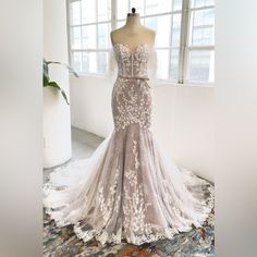 a wedding dress on display in front of a window