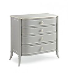 a white chest of drawers with three drawers and one drawer on the bottom, in front of